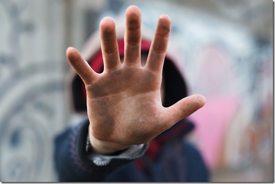 dramatic portrait of a little homeless boy, dirty hand