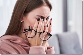 Woman rubbing dry irritated eyes