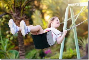 Child swinging on playground. Kids swing.