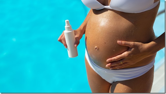 Pregnant woman on summer at swimming pool