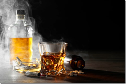 Alcohol and drug addiction. Whiskey in glass, syringe, pills and cigarettes on wooden table, space for text