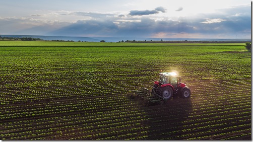 Tractor cultivating field at spring 