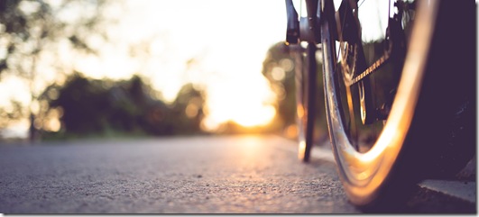 Road bike parked on a beautiful road sunset, warm light with copy space.