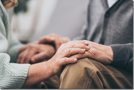 cropped view of retired couple holding hands 