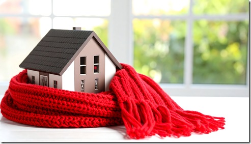 Small house model wrapped in a red scarf near a window